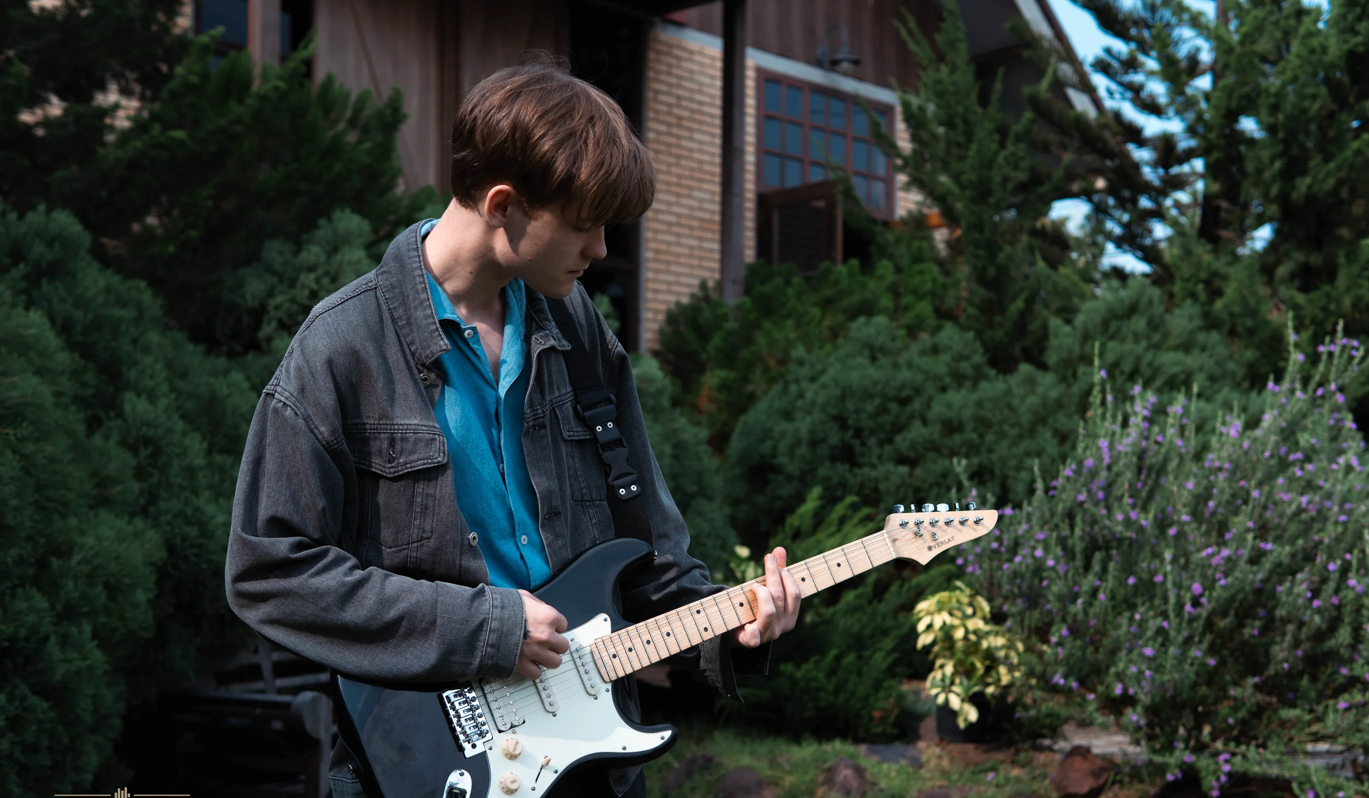 Musician playing an OVERLAY electric guitar